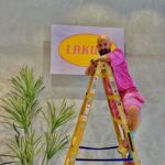 אדיר קדישא עומד על סולם תולה שלט שכתוב עליו לקום.