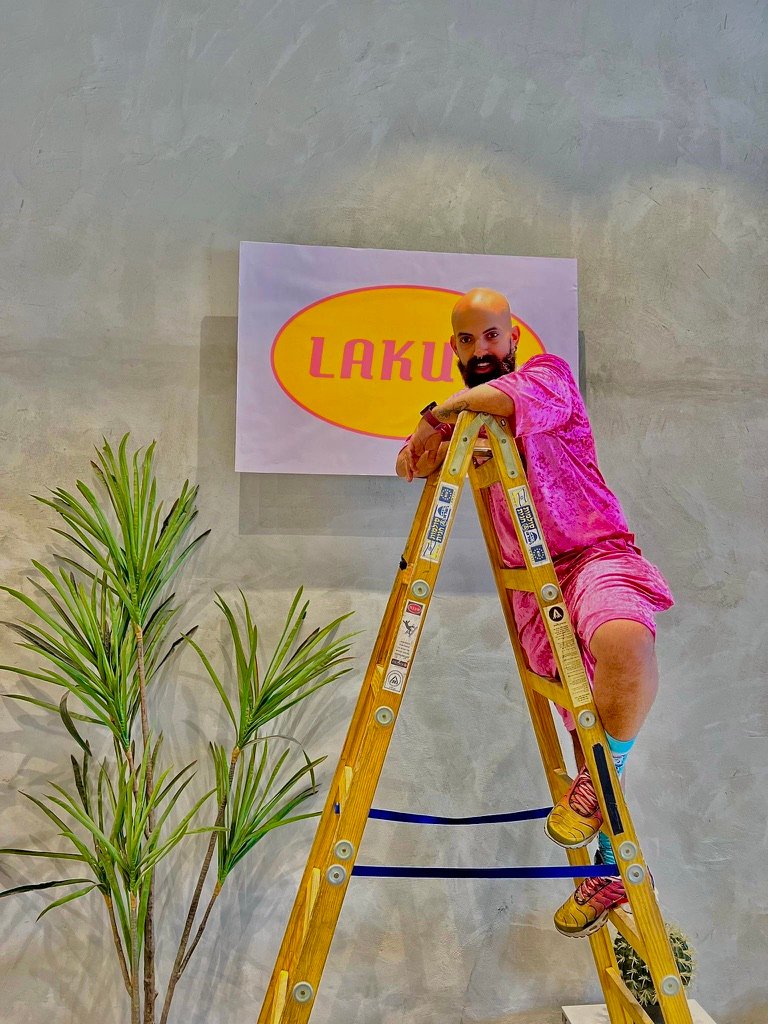 אדיר קדישא עומד על סולם תולה שלט שכתוב עליו לקום.