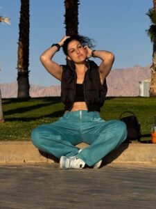 צ׳ארלי מור מסדרת את השיער מול הרי אילת