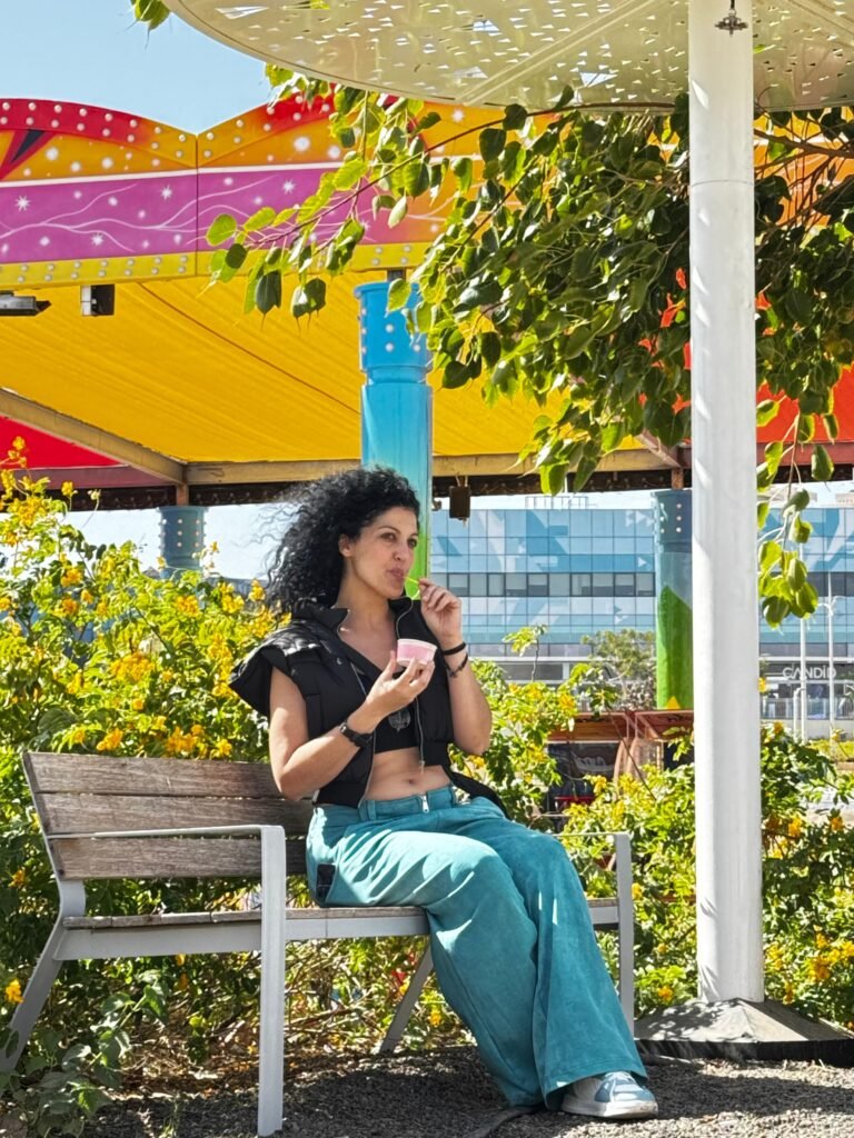 משתתפת מצולמת בישיבה על ספסל באור טבעי